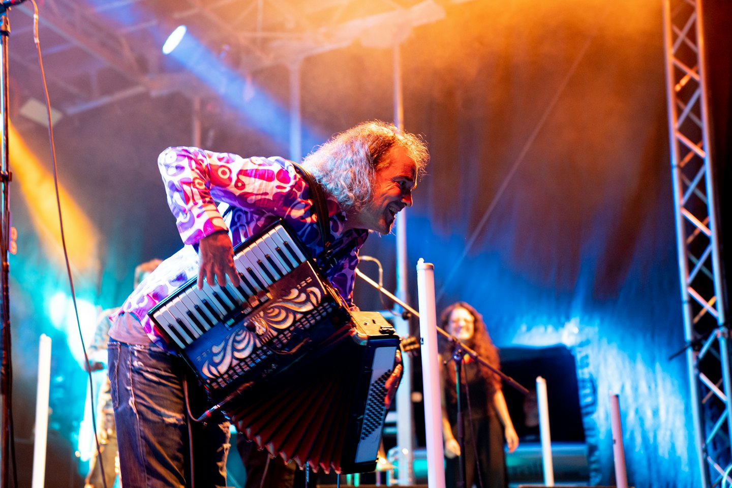 Oudere man speelt zwarte accordeon op een concertpodium.