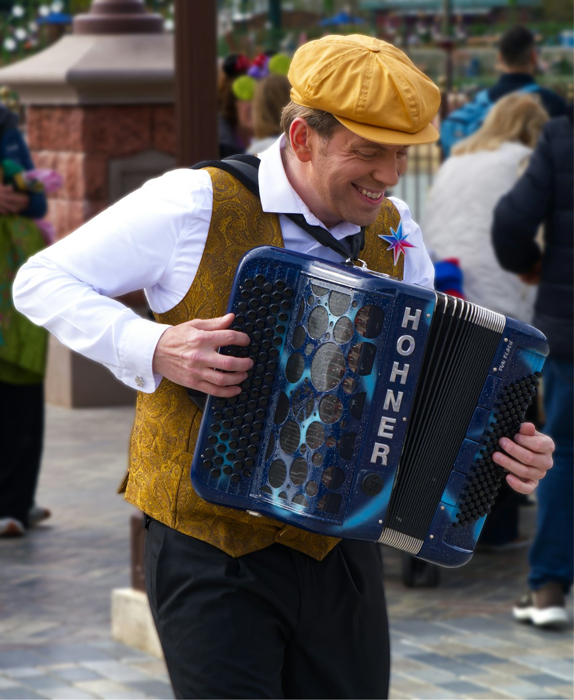 Een man speelt op een blauw-zwarte accordeon op straat.