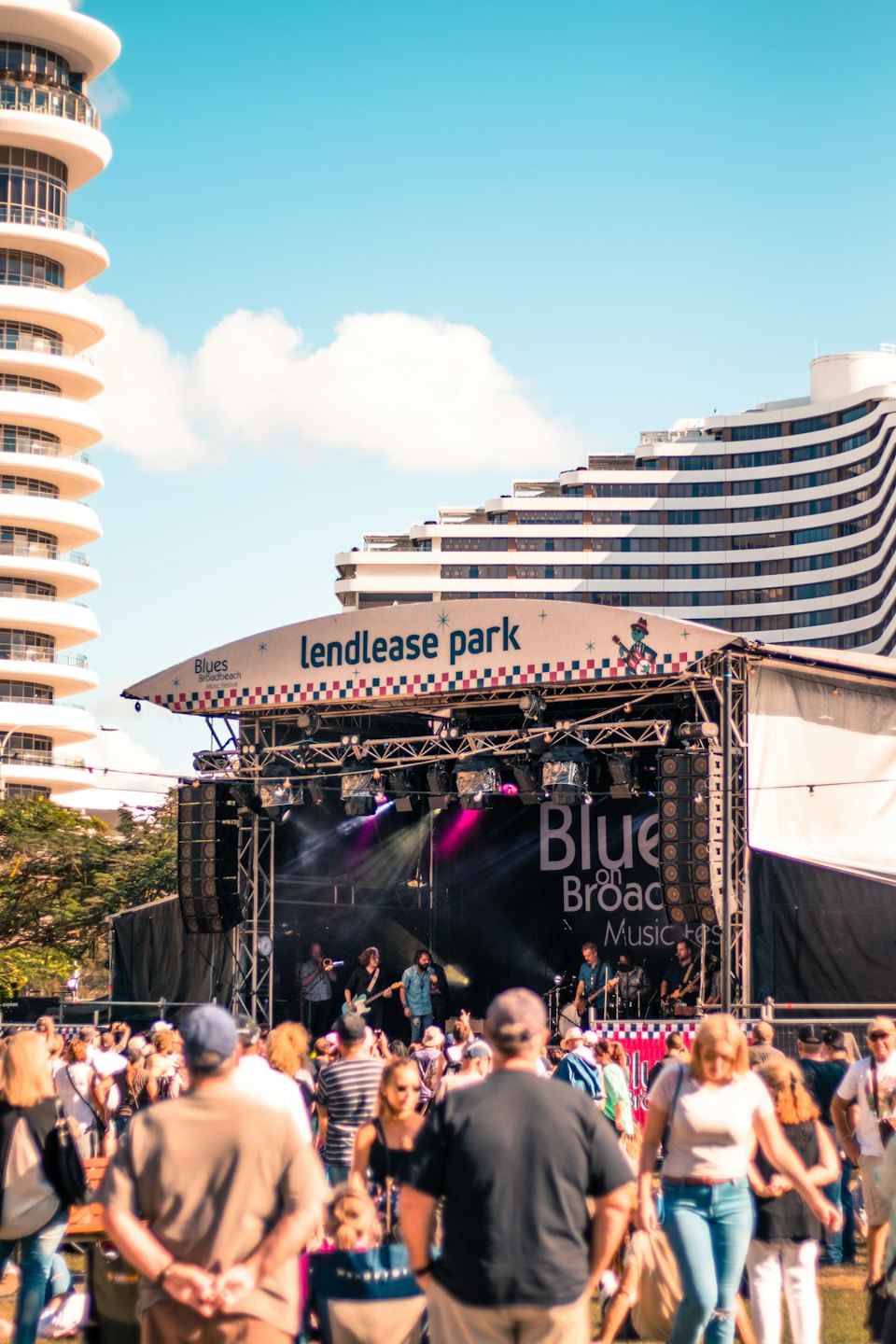 Band speelt op podium op buitenmuziekfestival met publiek.