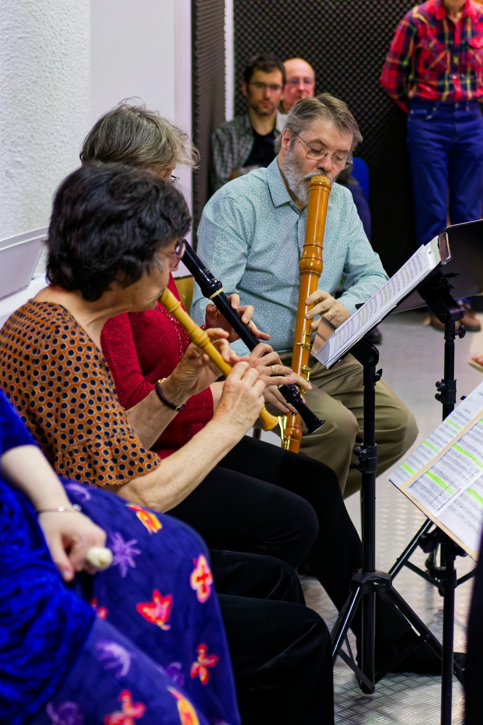 Een groep muzikanten die fluiten spelen tijdens een repetitie.
