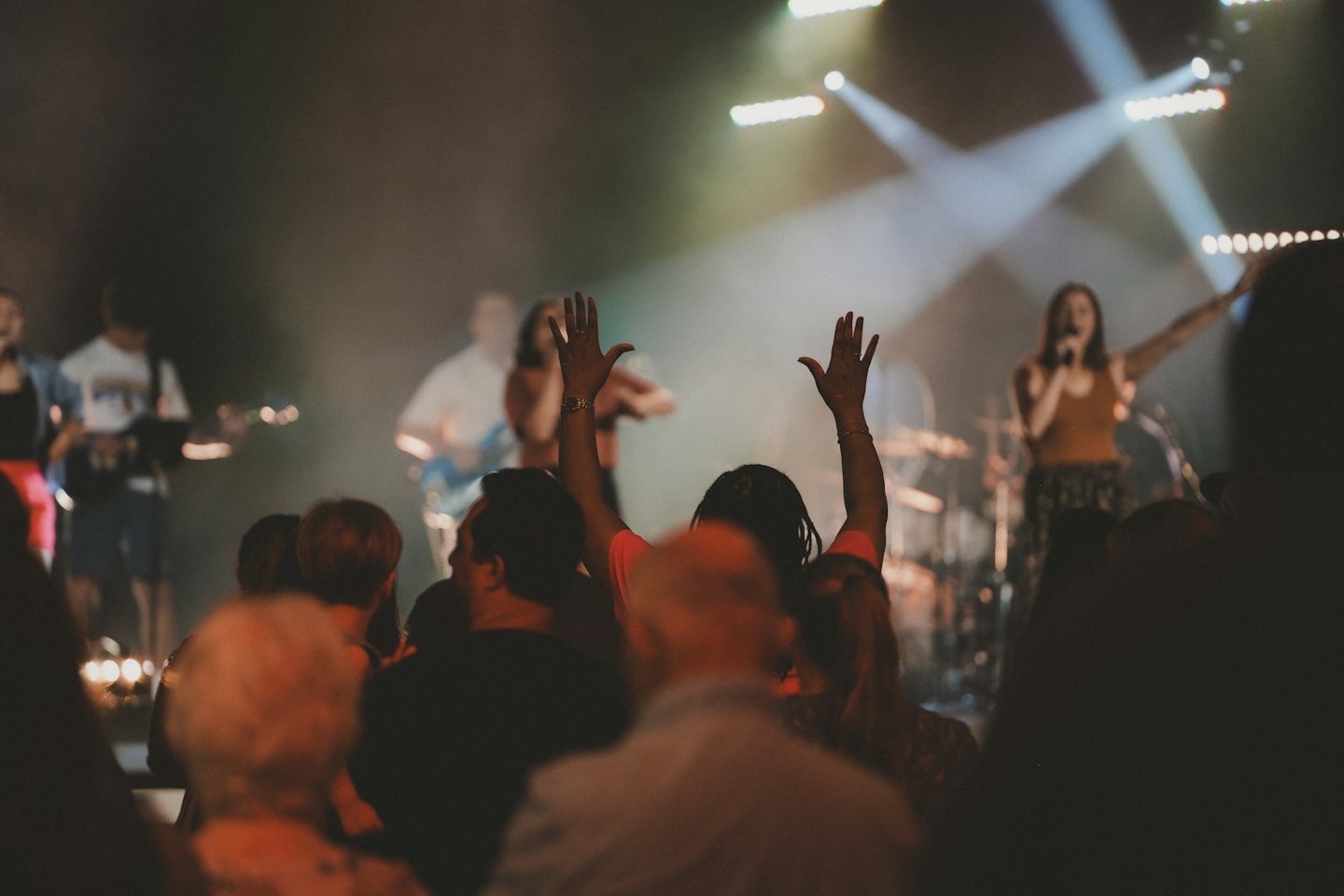 Publiek steekt handen op tijdens een muzikaal optreden.