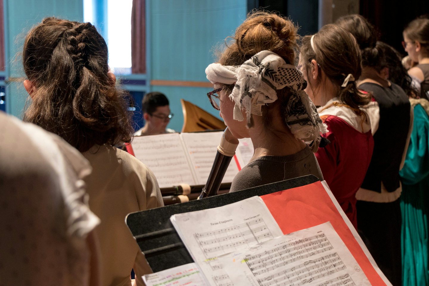 Muzikanten die blokfluiten spelen en bladmuziek vasthouden tijdens een repetitie.